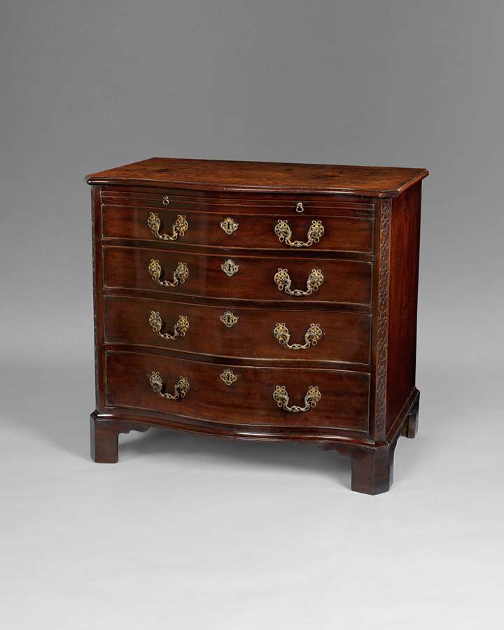 A George III period mahogany serpentine commode